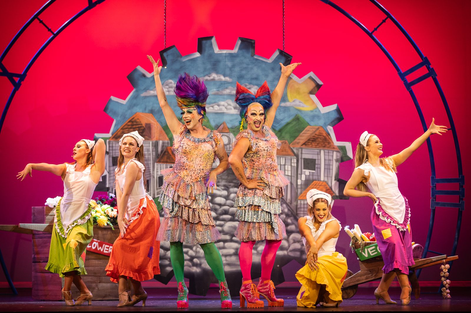 The Cinderella ensemble in bright costumes in front of a castle backdrop, Zealous Productions Christmas pantomime, December 2021