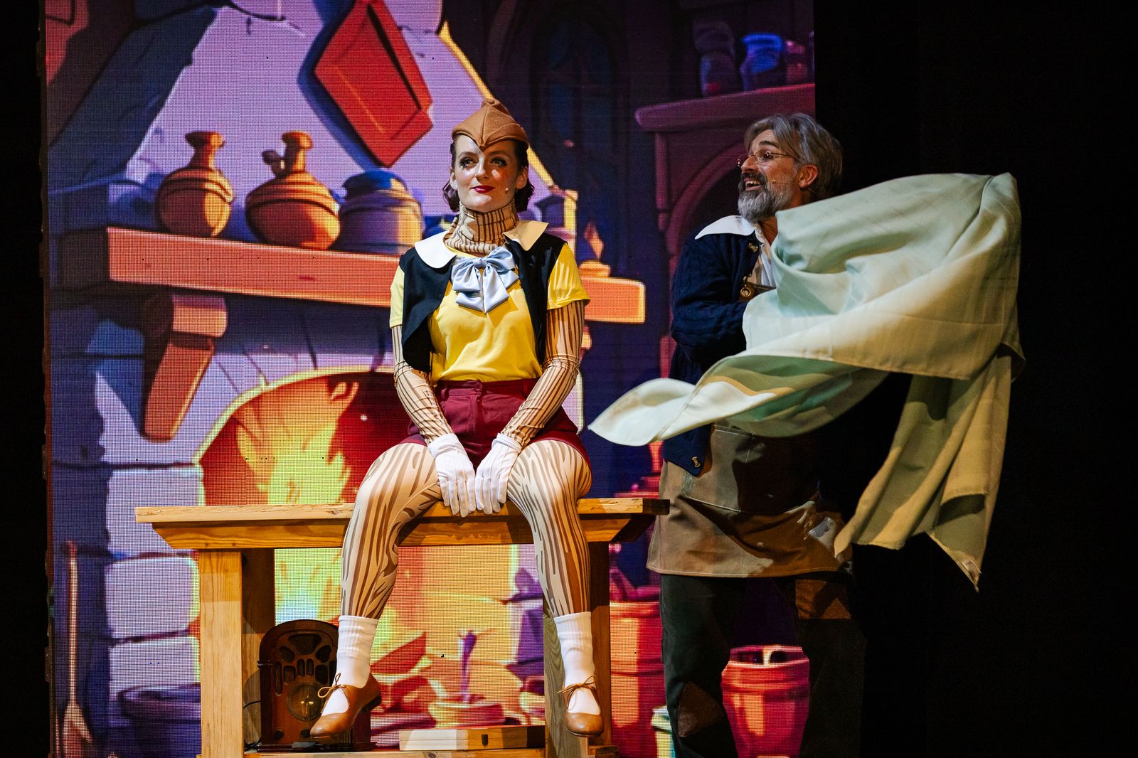 Pinocchio sitting by the fireplace in Geppetto's workshop, Pinocchio pantomime by Zealous Productions, December 2024