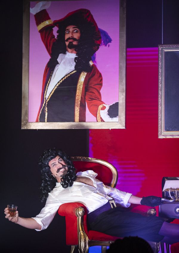Captain Hook lounging in a red chair beneath his own portrait, Zealous Productions' Peter Pan pantomime, December 2022