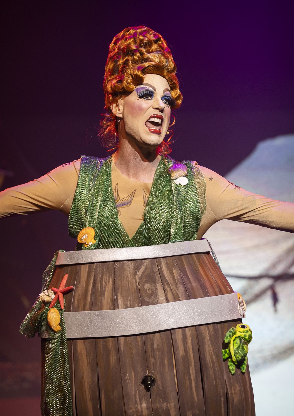 The pantomime dame in a ginger beehive wig and a barrel costume, Zealous Productions' Peter Pan, December 2022